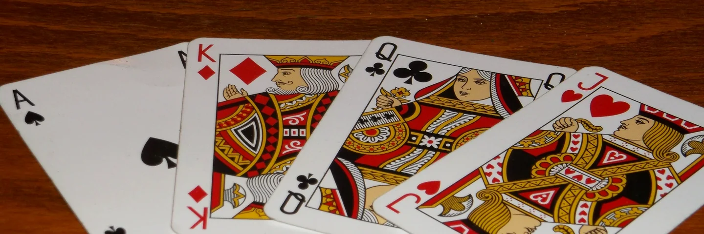 A fan of playing cards on a wooden table