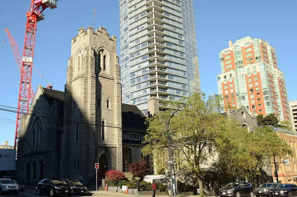 A construction crane and towers rise behind First Baptist Church in downtown Vancouver