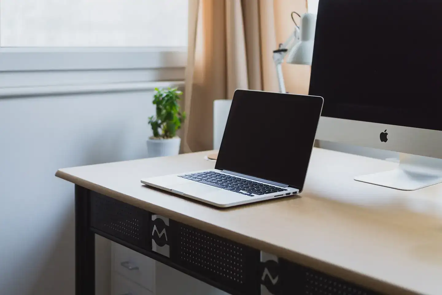 A laptop and desktop computer on a home-office desk