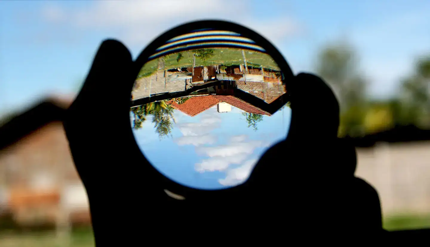 Magnifying glass / biconvex lens creates a distant scene upside-down and smaller