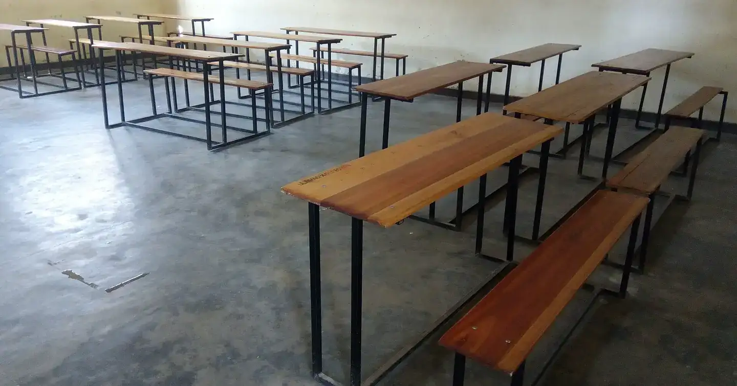 Wooden desks and benches in an empty classroom