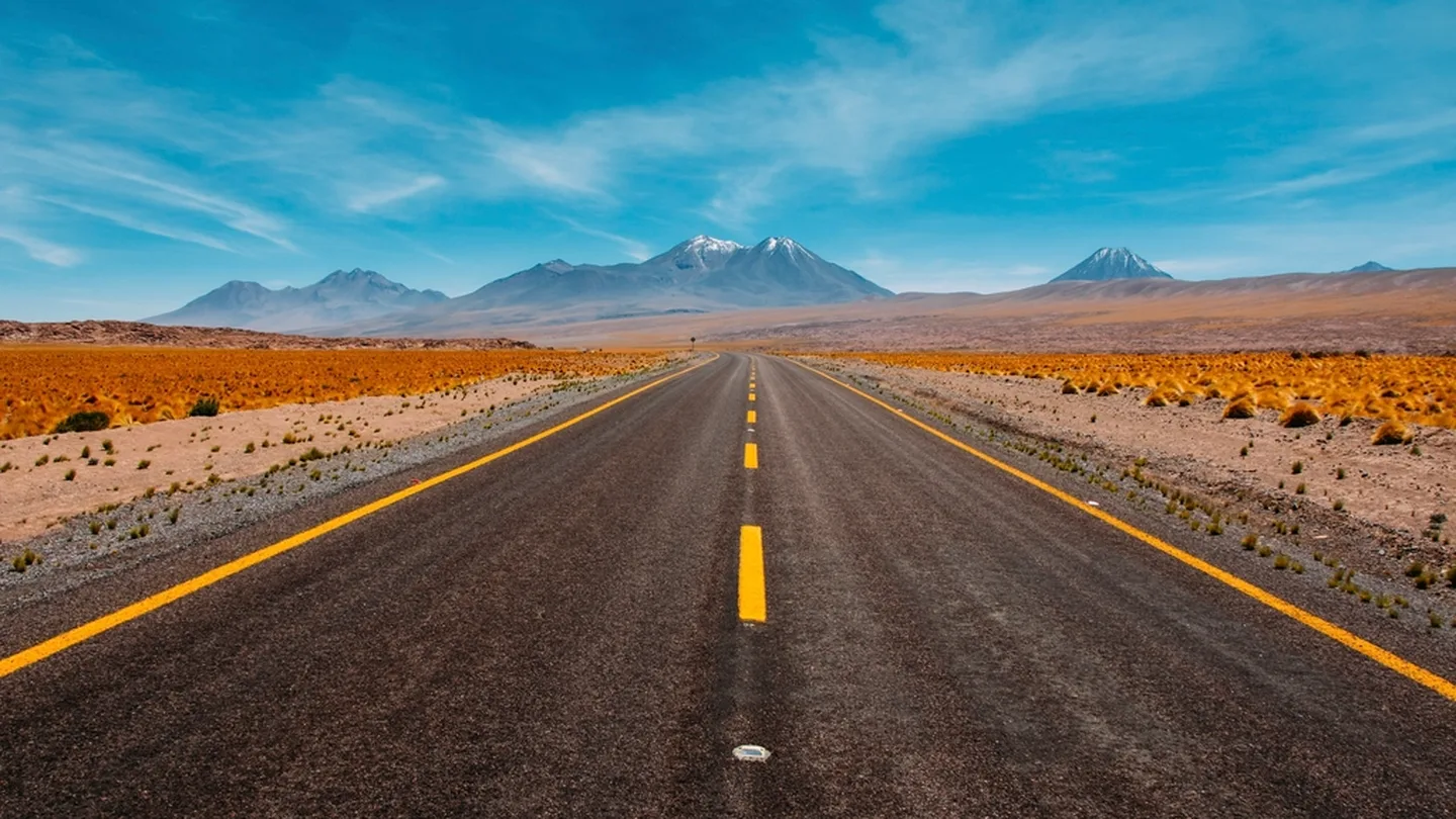 An open highway running toward distant mountains